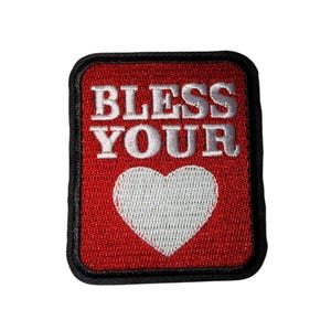May include: Embroidered patch with a red background, black border, and white text that reads "BLESS YOUR" above a white heart. The patch is rectangular with rounded corners.