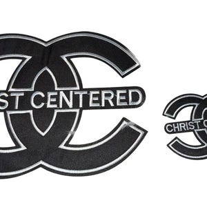 May include: Black and silver embroidered patch with the text "CHRIST CENTERED" in a stylized design. Includes a larger and smaller version of the patch. The patches have a black background and silver trim.