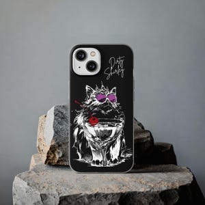 May include: A black smartphone case featuring a white line art illustration of a fluffy cat wearing a crown and purple sunglasses. The cat is holding a cocktail glass with a red cherry. The text Dirty Shirley is written in white script above.
