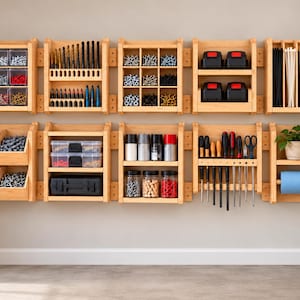 May include: A wall-mounted wooden tool storage system consisting of ten modular shelves and bins. The units hold various hardware, drill bits, batteries, hand tools, fasteners in clear containers, and a roll of blue paper towels.