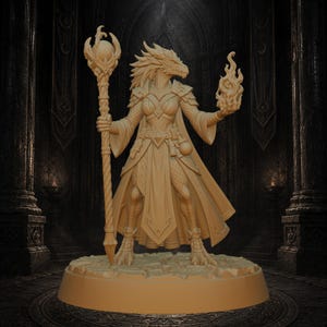May include: A beige monochromatic miniature figurine of a dragon-like humanoid character standing on a circular base. The figure wears layered armor and robes, holds a tall staff topped with a sphere, and displays a flame effect in the left hand.