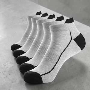 May include: A set of five ankle socks in a light heather gray color. Each sock features a solid black toe, a black heel patch, and a thin black line detail running along the side. The fabric has a visible knit texture throughout the design.