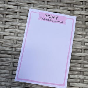 May include: A rectangular notepad with a light pink border and a pink header strip featuring the text "TODAY (but probably tomorrow)" in black lettering. The center of the notepad is blank and white, providing space for writing notes or daily tasks.