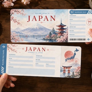 Könnte beinhalten: Zwei dekorative Bordkarten mit japanischen Illustrationen. Eine zeigt den Fuji und eine Pagode, die andere eine Karte von Japan mit einer roten Sonne. Beide haben Platz für Passagierdetails und das Wort "JAPAN".