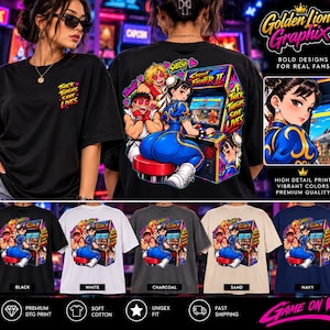 May include: A black t-shirt featuring a graphic print of Street Fighter II characters and an arcade cabinet on the back, with the text Thick Thighs Save Lives. The front chest area displays the same text in a smaller yellow and pink font.