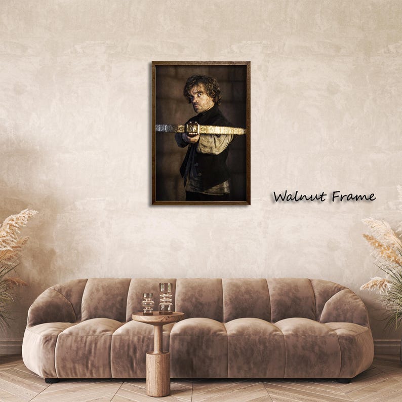 May include: A framed print featuring a man holding a prop sword. The artwork is set in a dark walnut frame. The text "Walnut Frame" is displayed on the wall. The image is displayed above a brown sofa.