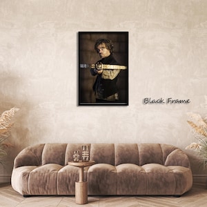 May include: A framed portrait featuring a man holding a crossbow. The image is set against a neutral background, with the text "Black Frame" visible. The frame is black, and the overall aesthetic is artistic.