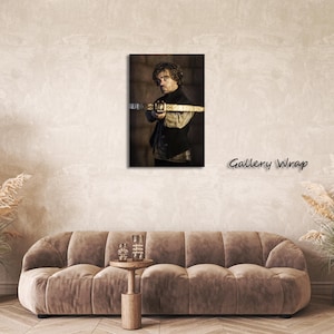 May include: A framed canvas print featuring a portrait of a man holding a crossbow. The image has a sepia tone, with the text "Gallery Wrap" in the lower right corner. The man is wearing a dark vest and shirt.