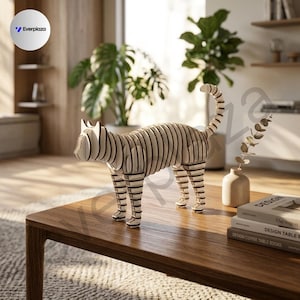 Könnte beinhalten: Eine dekorative Katzenfigur aus geschichteten, hellen Holzscheiben mit dunklen Kanten. Die Skulptur hat ein segmentiertes, geripptes Aussehen, das die Form einer stehenden Katze mit aufrechtem Schwanz bildet und auf einer Holzoberfläche steht.