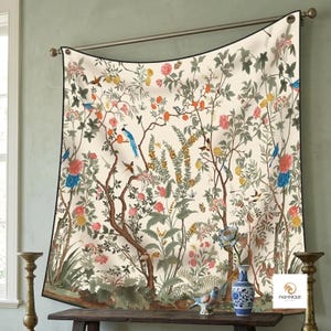 May include: A rectangular wall tapestry featuring a cream-coloured background with a detailed botanical print of brown tree branches, green foliage, and various colourful flowers in shades of pink, blue, and yellow, along with small birds.