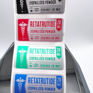 May include: A stack of four labels with the text "RETATRUTIDE" and "LYOPHILIZED POWDER". Each label has a different colored background: black, red, green, and blue. The labels also include the text "20 MG", ">99% PURITY", and "RESEARCH USE ONLY".