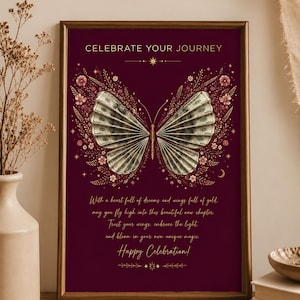 Puede incluir: Una impresión vertical enmarcada con fondo burdeos oscuro que presenta un gráfico central de mariposa con alas hechas de billetes plegados. El texto dice CELEBRATE YOUR JOURNEY e incluye un poema sobre sueños, alas y oro.