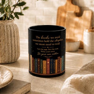 Könnte beinhalten: Ein schwarzer zylindrischer Becher mit einer Reihe bunter illustrierter Bücher am Boden und goldenem Text: The books we avoid sometimes hold the chapters we most need to read. Turn the page. Face the truth. Write a new story. Be your own author.