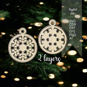 May include: Two circular light-colored wooden ornaments featuring intricate snowflake cutouts. The design consists of 2 layers. Text on the image reads: Digital File, SVG, CDR, DXF, EPS, PNG, AI, 2 layers.