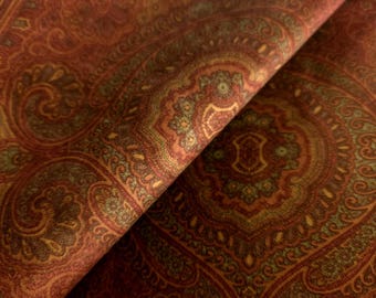 May include: A fabric featuring a dense, intricate paisley pattern in shades of deep rust, burnt orange, and muted olive green. The design consists of repeating teardrop and floral motifs arranged in a symmetrical, ornate layout across the surface.