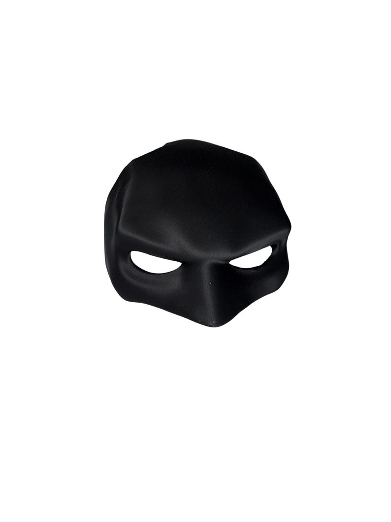 Op de afbeelding: Een zwart, gevormd masker met oogopeningen en een neusuitsparing. Het masker is gemaakt van een glad, mat materiaal en is ontworpen om het bovenste deel van het gezicht te bedekken. Het masker is waarschijnlijk voor kostuum- of theatrale doeleinden.