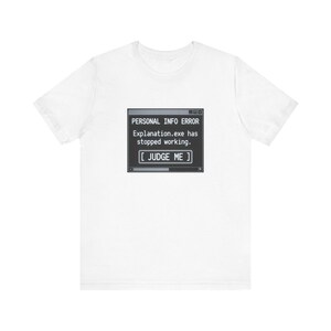 May include: A white short-sleeve t-shirt featuring a centered graphic of a computer error window. The black box displays the text: PERSONAL INFO ERROR, Explanation.exe has stopped working, and a button labeled [ JUDGE ME ] in white font.