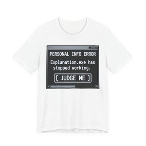Könnte beinhalten: Weißes T-Shirt mit einem schwarzen Grafikdesign, das einer Computerfehlermeldung ähnelt. Der Text lautet: "PERSONAL INFO ERROR Explanation.exe has stopped working. [ JUDGE ME ]".