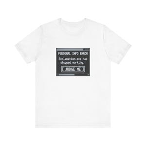 May include: A white short-sleeve t-shirt featuring a centered graphic of a computer error window. The black box displays the text: PERSONAL INFO ERROR, Explanation.exe has stopped working, and a button labeled [ JUDGE ME ] in white font.