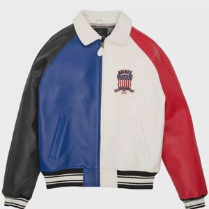 May include: A color-blocked leather jacket in black, blue, white, and red. The jacket features a white collar, a zipper closure, and a ribbed hem and cuffs with black and white stripes. An emblem with text is on the front.