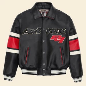 Pu&ograve; includere: Giacca in pelle nera con la scritta "Avirex" in bianco e rosso. La giacca presenta strisce rosse e bianche sulle maniche e un orlo e polsini a righe. Un classico stile bomber.