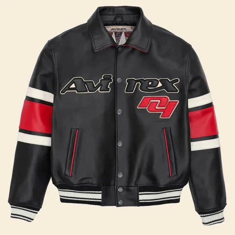 Pu&ograve; includere: Giacca in pelle nera con la scritta "Avirex" in bianco e rosso. La giacca presenta strisce rosse e bianche sulle maniche e un orlo e polsini a righe. Un classico stile bomber.