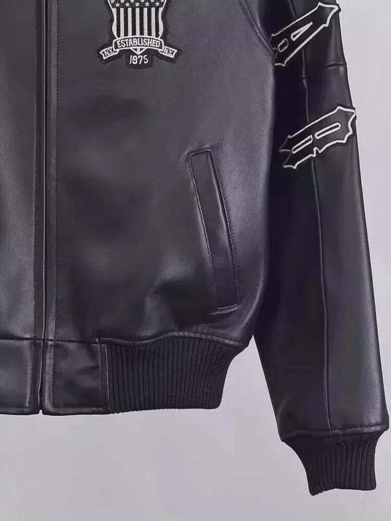 May include: Black leather jacket with white embroidered details on the sleeves and a patch on the chest. The patch reads "NY ESTABLISHED NY 1975". The jacket has a ribbed hem and cuffs.
