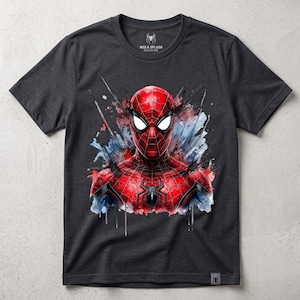 May include: A charcoal gray short-sleeve t-shirt featuring a vibrant red and blue watercolor-style graphic of a masked superhero on the chest. The inner neck label displays the text Web & Splash Collective with a small spider icon.