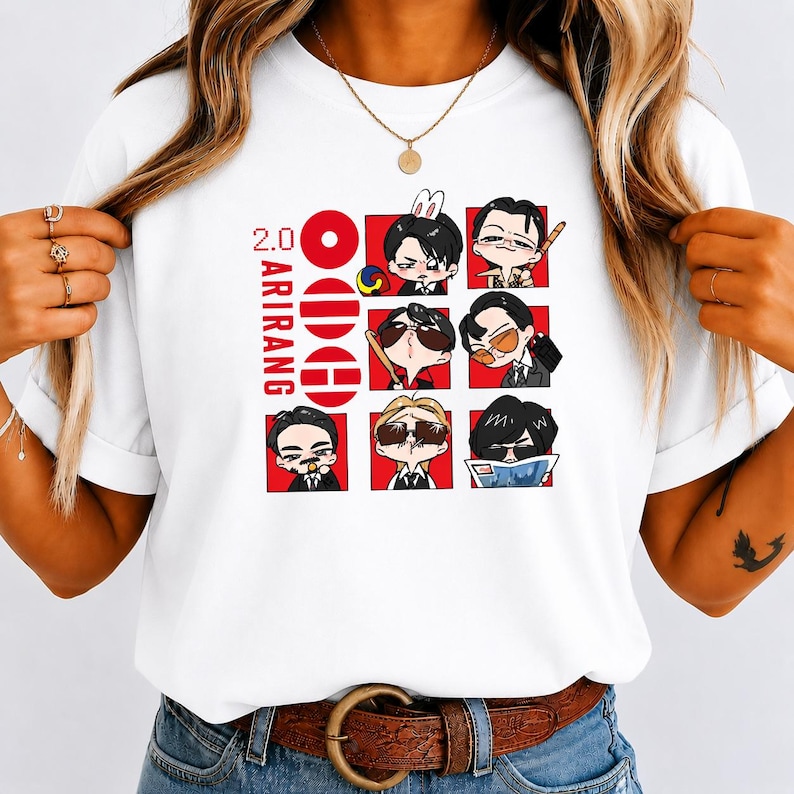 May include: A white t-shirt featuring a graphic print with the text 2.0 ARIRANG. The design includes a vertical column of three red circles and a grid of six cartoon character illustrations in various poses, wearing sunglasses and formal attire.