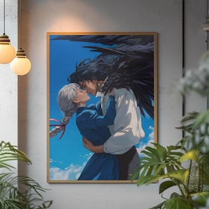 Op de afbeelding: Een rechthoekige wandkunstprint in een dunne houten lijst met een illustratie van twee figuren die elkaar omhelzen tegen een helderblauwe lucht met witte wolken. Eén figuur heeft lang zilverkleurig haar in een vlecht en een blauwe jurk, de andere heeft donker haar en grote zwarte vleugels.