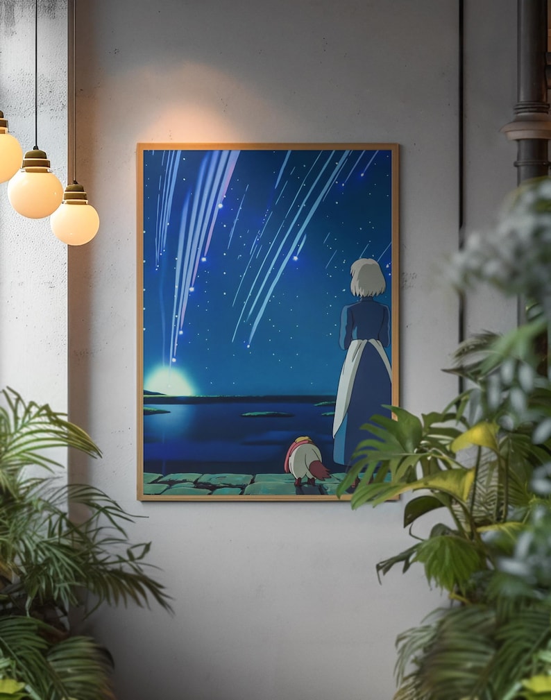 May include: A rectangular wall art print in a thin wooden frame depicting an animated scene of a person with short light hair and a blue dress standing beside a small creature on a stone path, looking at a night sky filled with bright shooting stars.