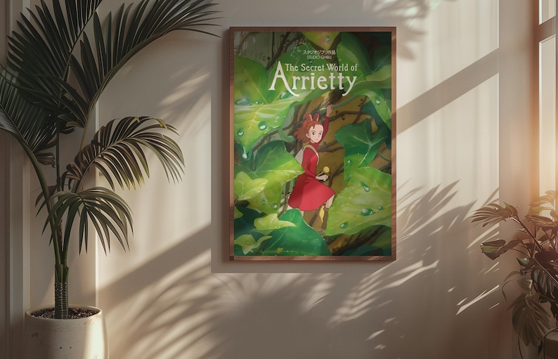 Pu&ograve; includere: Un poster incorniciato di "Arrietty - Il mondo segreto sotto il pavimento" con una ragazza in abito rosso in mezzo a un rigoglioso fogliame verde. Il poster &egrave; in una cornice di legno, appeso a una parete beige.