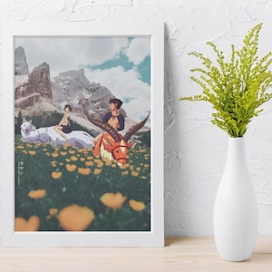 May include: A framed print depicting an anime-style illustration of characters riding mythical creatures in a field of yellow flowers, with mountains in the background. The print is in a white frame, and a white vase with green foliage is to the right.