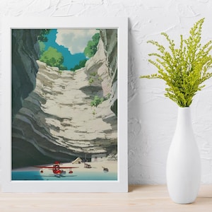May include: A framed art print depicts a canyon scene with a red airplane on a beach. The artwork features a detailed illustration of layered rock formations, a blue sky with clouds, and green foliage. A white vase with green plants is on a wooden surface.