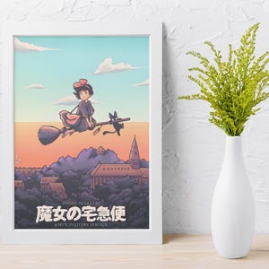 Op de afbeelding: Een ingelijste kunstdruk met een figuur met een rode strik die op een bezemsteel met een zwarte kat over een stad vliegt. De tekst luidt Hayao Miyazaki, Kiki's Delivery Service en de Japanse tekens 魔女の宅急便. Het is in een witte lijst.