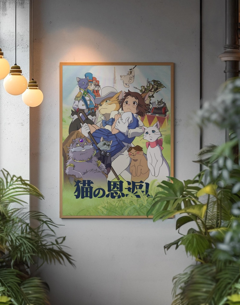 May include: A framed poster featuring a colorful anime illustration with several cat characters. The Japanese text "猫の恩返し" is visible at the bottom. The artwork is set against a neutral wall, with hanging lights and plants in the foreground.