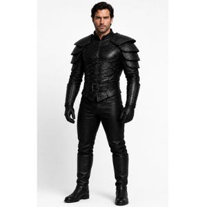 May include: A full black leather armour set. The jacket has studded details and shoulder pauldrons. The set includes matching trousers, gloves, and knee-high boots. The outfit is designed for costume or cosplay purposes.