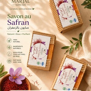 Può includere: Tre saponette rettangolari allo zafferano, ciascuna avvolta in cartone ondulato ed etichettata con il marchio "MARJAL" e le parole "Savon au Safran". L'immagine include una ciotola di zafferano e un fiore viola.