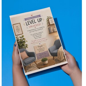 May include: A rectangular card featuring the text SUPERVISEE STATUS: LEVEL UP UNLOCKED! Congratulations on completing your learning adventure! You asked the questions. You did the work. You showed up. You're ready. The field and your future clients are lucky to have you. Thanks for letting me be a small part of your training. Now go be an amazing therapist! I'll be over here cheering for you! The card displays an interior scene with two gray armchairs, a wooden coffee table, and a potted plant.