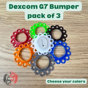 May include: A pack of three Dexcom G7 bumpers in various colors, including red, green, black, orange, blue, and grey, arranged around a central white Dexcom G7 sensor. The text Dexcom G7 Bumper pack of 3 and Choose your colors is visible.