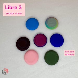 May include: Seven circular Libre 3 sensor covers in various solid colors including blue, purple, pink, dark green, and a multi-colored gradient. The text Libre 3 sensor cover is visible in the top left, and Each sold separately is in the bottom right.