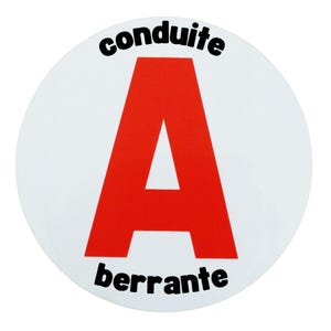 Puede incluir: Una pegatina circular blanca con una gran letra "A" roja en el centro. Las palabras "conduite" y "berrante" están impresas en negro encima y debajo de la letra. La pegatina es probablemente para un vehículo.