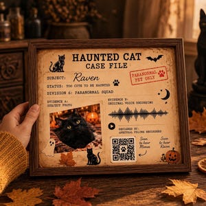 May include: A framed Haunted Cat Case File print featuring a black cat named Raven. The document includes a subject photo, a sound wave graphic, a QR code, and text such as Paranormal Pet Only, Division 6: Paranormal Squad, and Evidence B.