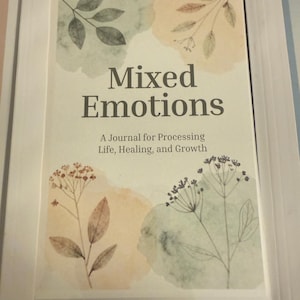 May include: A journal titled "Mixed Emotions" with a watercolor design. The cover features the title in a bold, dark font, with the subtitle "A Journal for Processing Life, Healing, and Growth." Watercolor floral and leaf illustrations in muted tones of green, peach, and brown.