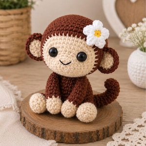 May include: A handmade crochet monkey doll in brown and cream colors, with a white flower accent. The monkey has black safety eyes and is sitting on a wooden slice. A charming, soft toy.