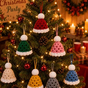 May include: A collection of seven crocheted hat ornaments in red, green, pink, beige, yellow, gray, and blue. Each hat features a white pom-pom on top, a white crocheted brim, and a matching hanging loop, displayed as festive holiday decorations.