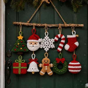 May include: A wall hanging featuring ten crocheted Christmas ornaments suspended from a wooden branch. The ornaments include a tree, Santa Claus, snowflake, candy cane, stocking, gift, bell, gingerbread person, wreath, and a striped ball.