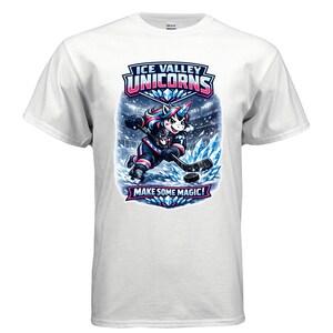 May include: White t-shirt featuring a cartoon unicorn playing hockey. The unicorn has a colorful mane and is wearing a hockey uniform. The shirt has the text "ICE VALLEY UNICORNS" and "MAKE SOME MAGIC!"