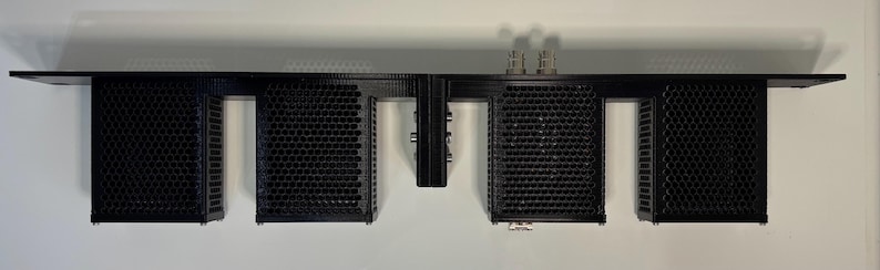 May include: A black electronic component with multiple rectangular sections. The sections have a perforated design. The component has several connectors and is mounted on a black frame. The item is designed for electronic equipment.