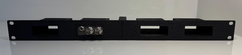 May include: A black rack mount panel with four rectangular openings and three circular connectors. The panel has mounting holes on each end and a raised section in the center. The product is designed for electronic equipment.